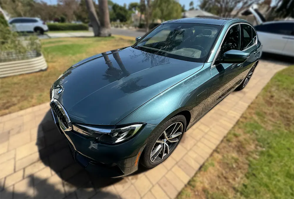 Green BMW sedan after detailing in a driveway